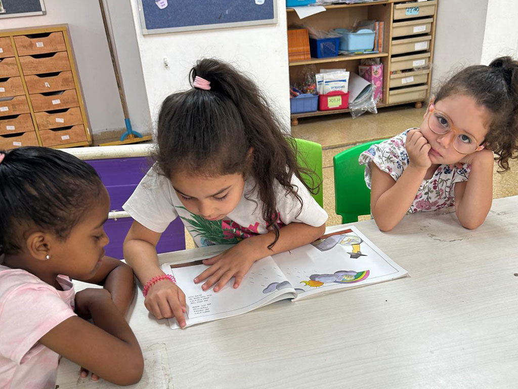 Three female students are reading a book