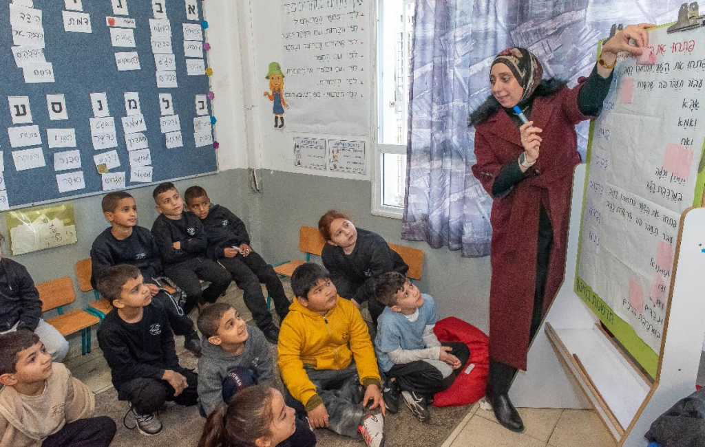 Second graders at Maanit elementary school in Ramle review a composition in their specially-designed classroom. New words will be added to the bulletin board after the lesson.